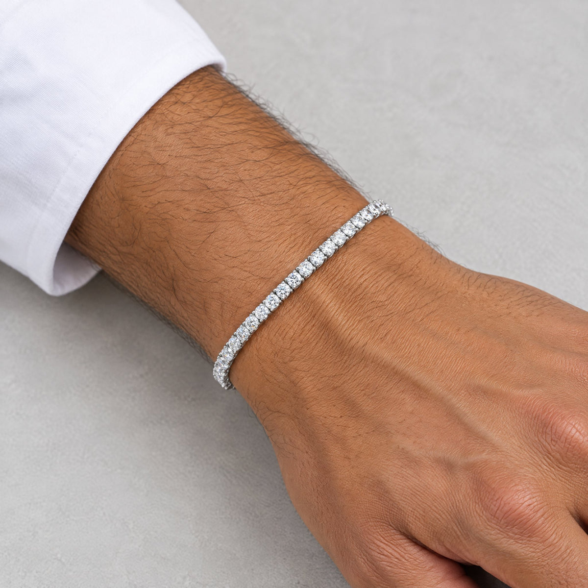 Man wearing a 3mm tennis bracelet below a white shirt cuff