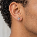 Cross stud earring worn on the earlobe