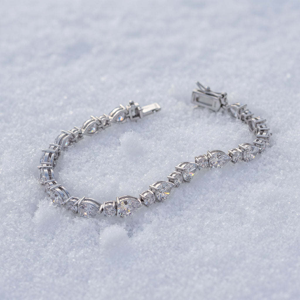 Pear-cut tennis bracelet lying on snow