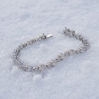 Pear-cut tennis bracelet lying on snow