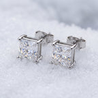 Pair of princess-cut moissanite studs on snow