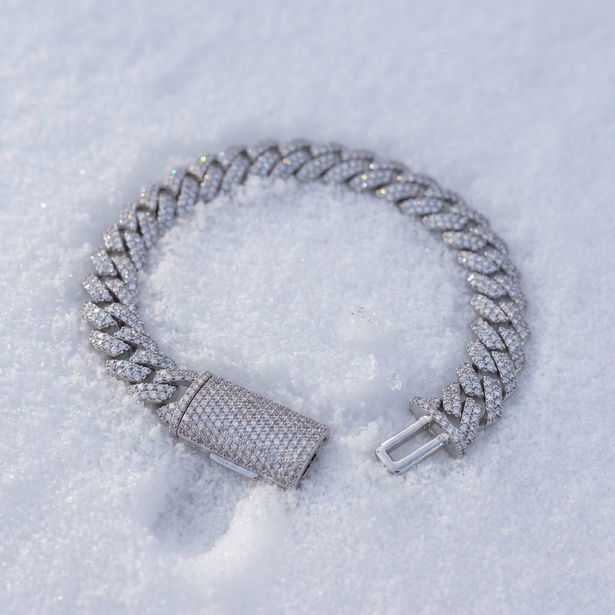 10mm iced Cuban link bracelet resting on fresh snow