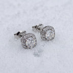Pair of halo stud earrings on snow