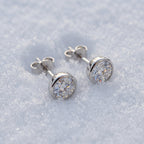 Pair of round solitaire studs on snow