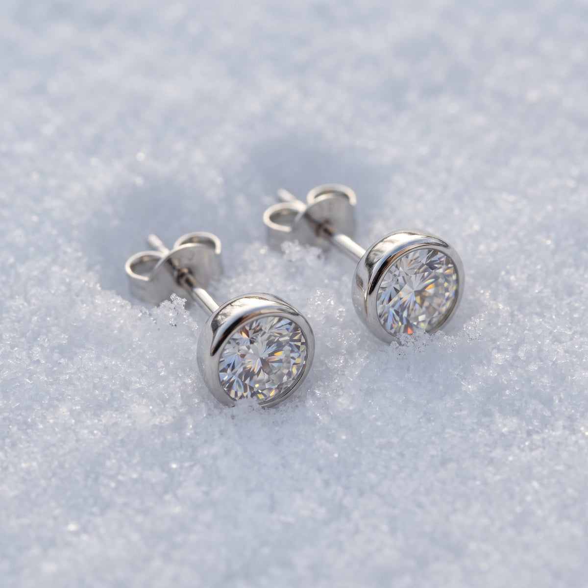Pair of round solitaire studs on snow