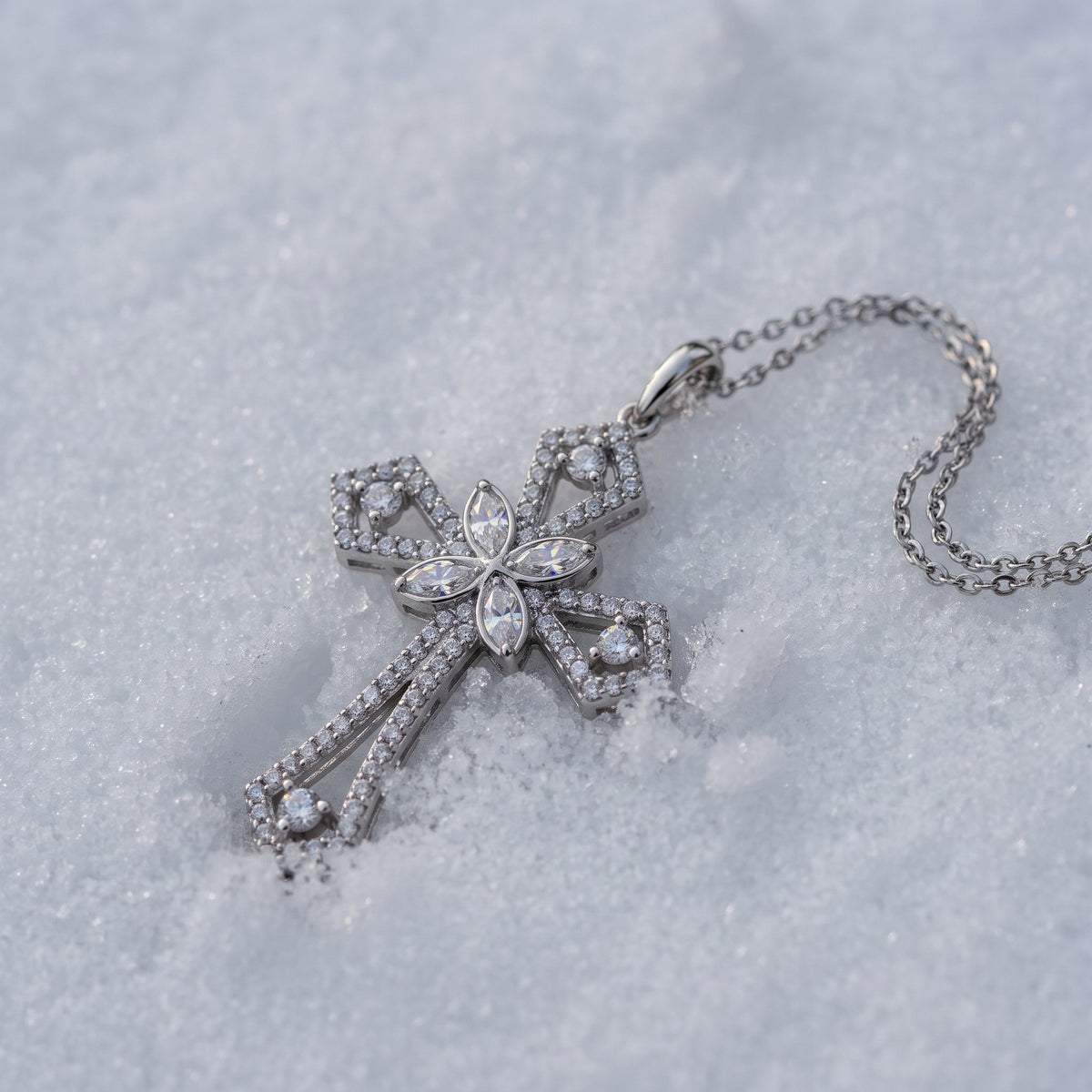 Statement cross pendant lying on snow
