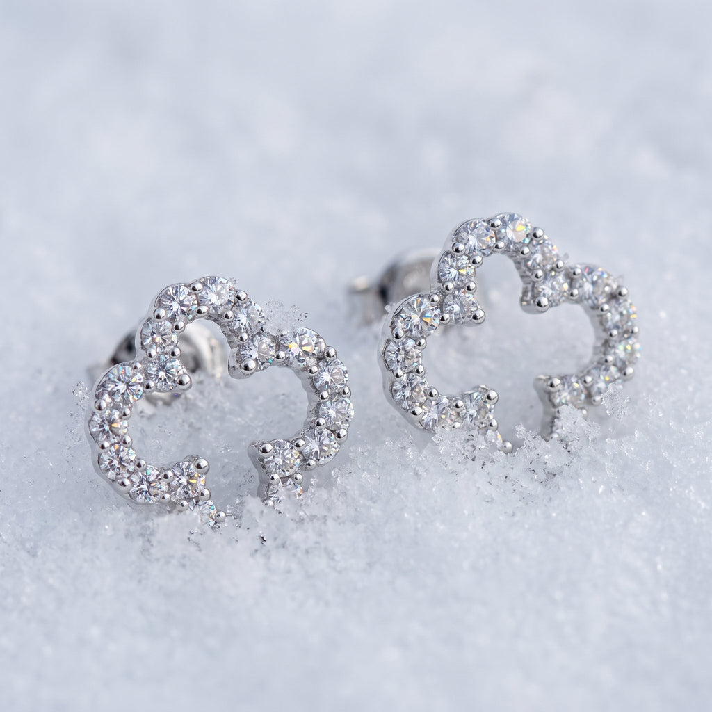Pair of clover outline earrings on snow