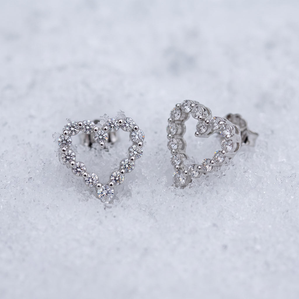 Pair of heart outline earrings on snow