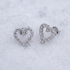 Pair of heart outline earrings on snow