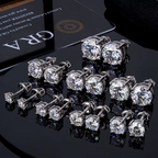 Round moissanite studs in several sizes on a black surface with a GRA card