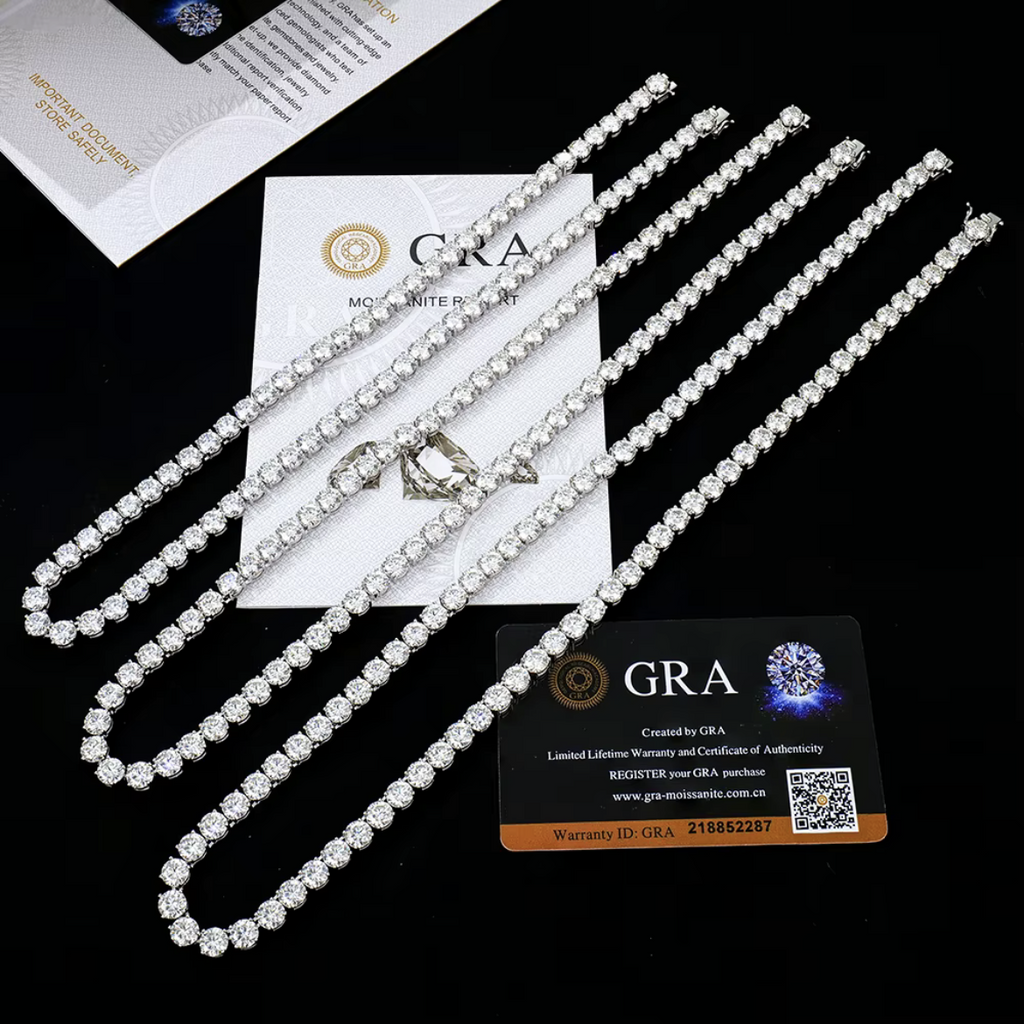 Tennis chains laid on a black surface with GRA moissanite report cards