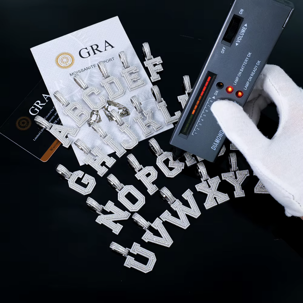 Moissanite initial letters with a GRA report card and a handheld gem tester