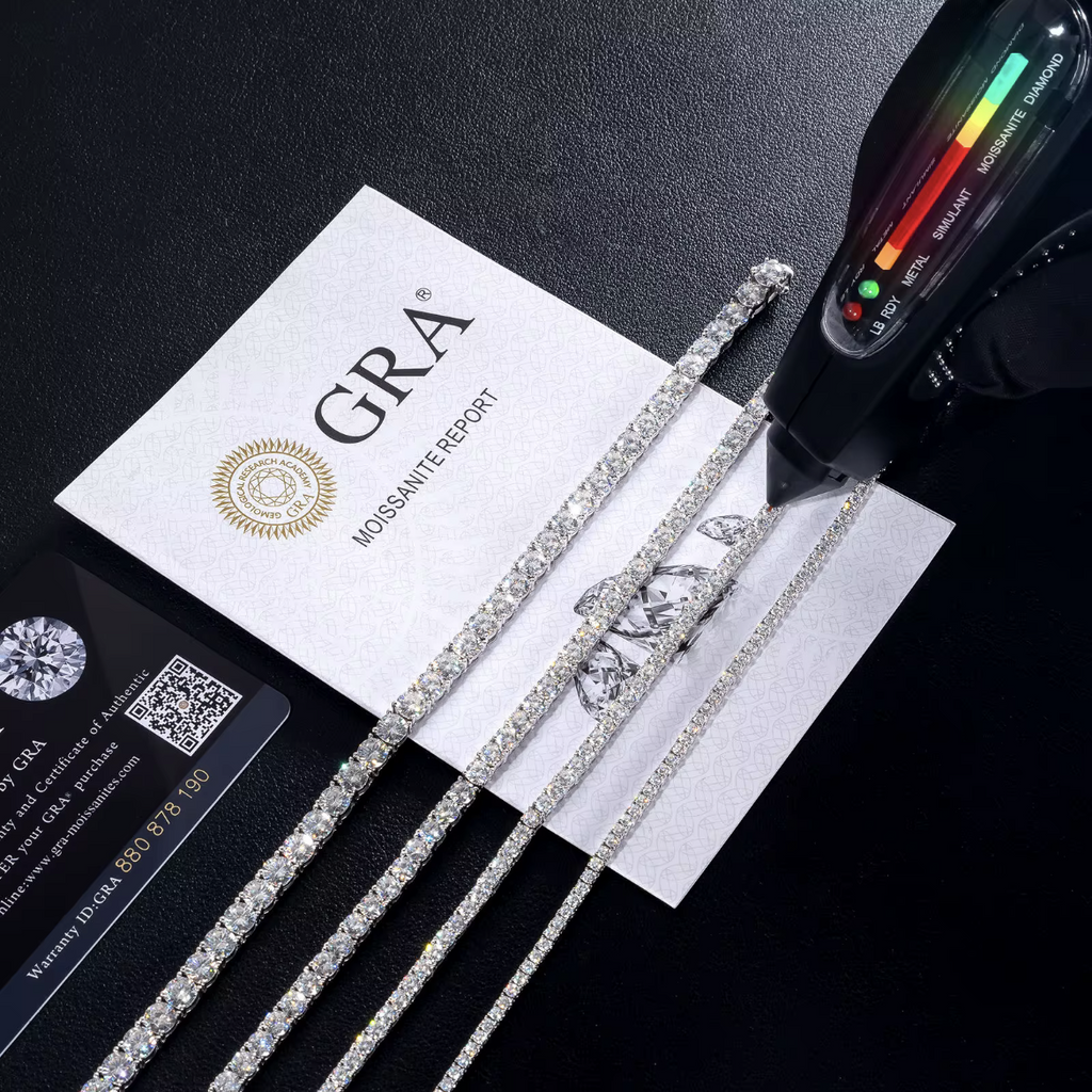 Tennis chains beside a GRA moissanite report card and a handheld gem tester